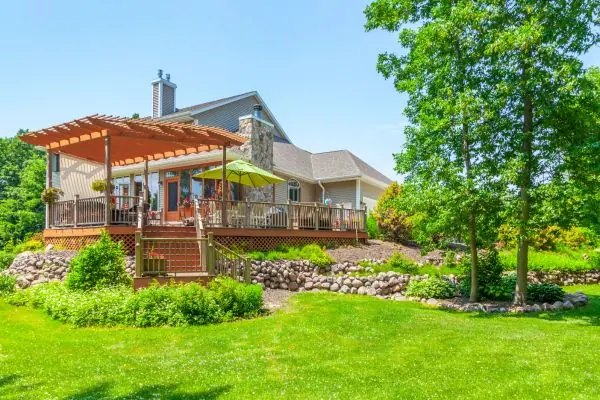 beautiful landscaped yard and deck with pergola