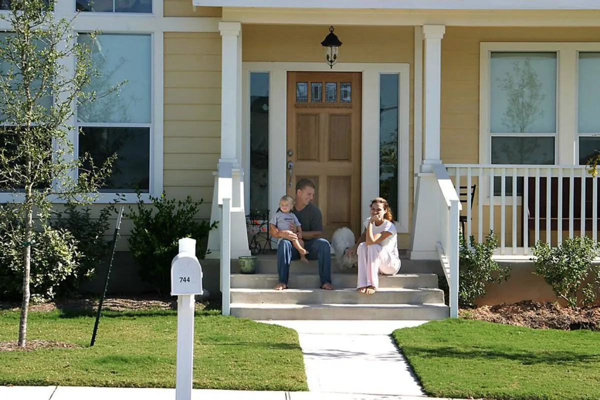 family sitting in front porch with dog